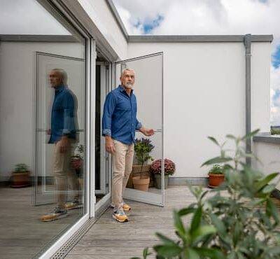 Mann öffnet eine Neher Fliegengitter Drehtür